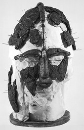 Black and white photograph taken during the second reconstruction, showing the fragments positioned on a head-sized block of plaster and supported with pins