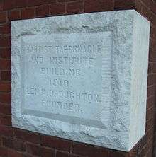 A white stone block inscribed with "BAPTIST TABERNACLE AND INSTITUTE BUILDING. 1910. LEN G. BROUGHTON, FOUNDER."