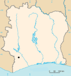 A blank map of a square-shaped country with a black dot designating the location of the site.