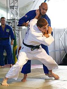 Judoka practicing tai otoshi throw in Judo class