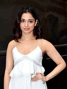 Tamannaah dressed in a white shirt and looking at the camera