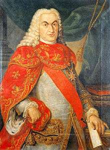 An elderly brown-eyed man wears a powdered periwig and a red sash, with, over this, the cross of the Constantinian Order of Saint George.