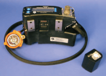 A photograph of a black apparatus on a headband with a digital readout. A smaller black part with a metal aparatus on its top is next to it.