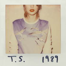 The cover is a polaroid of Swift with shoulder-length blonde hair wearing red lipstick and a long-sleeved sweater with a picture of birds in the sky. Her face is cut off by the frame above the nose and "T. S." and "1989" are written on the white polaroid frame with black marker.
