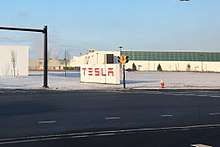 Large white sign with red letters spelling "TESLA"