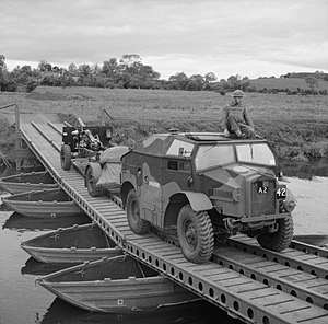Photograph of a complete 25 pounder gun, limber and 'Quad' tractor crossing a bridge (in the British Isles)