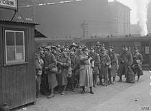 Scene at London Victoria station of troops on leave being directed by a member of the Volunteer Training Corps