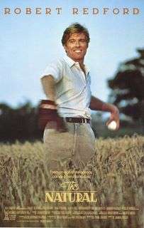 A man (Redford) standing in a field of waist high wheat, with a baseball ready to throw in one hand and a glove on the other