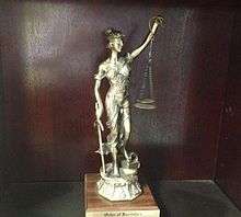 An image of a trophy awarded to a new member of the Order of the Barristers.  The trophy consists of a statute of Lady Justice.