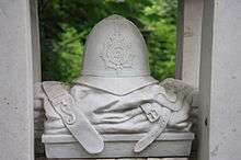 Sculpture showing a police helmet on top of a folded uniform