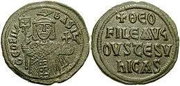 Image of bronze coin, a standing crowned man holding a labarum and a globus cruciger on the obverse, with a Greek-Latin inscription on the reverse