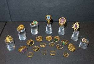 22 gold and jewelled rings in a display case