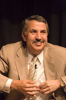 Thomas Friedman in suit clasping hands below chin.