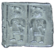 Black and white photograph of one of the Torslunda plates, showing two warriors with boar crested helmets