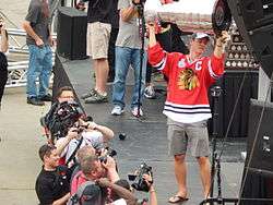 A man named Jonathan Toews, lifts the Stanley Cup.