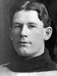 Cropped image of the head of a man in his early 20s, wearing a wool sweater, staring just past the camera
