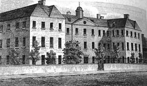 black and white image of large 3-storey building with lots of windows