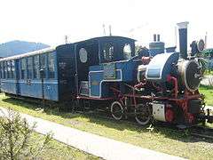 Blue locomotive and two passenger carriages