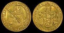 A golden coin depicting an armored middle-aged man on one side, and a coat-of-arms on the other side