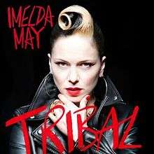 An image of a woman in a black leather jacket staring into the camera, with her hand elevated to her chin. Block handwritten text in red reads "Imelda May" to the top left and "Tribal" to the centre-bottom.