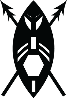 A black and white image of a stylised version of an African shield as a warrior's face with two crossed spears. The shield is encompassed by two circle arcs with white geometric shapes as cut-outs: rectangle at bottom, a larger hexagon (in the position of the mouth), another rectangle (in position of the nose) with two pairs of curved strips (as moustaches), two larger curved sections (in position of the eyes) and two small curved strips (as eyebrows). The spear heads are double pointed.