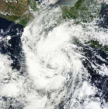 Satellite image of Carlotta developed a ragged central dense overcast, with a large area of thunderstorms and clouds.