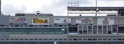 Five banners in a row at the top of the stadium press box with dates and logos for each bowl game, presented in chronological order from left to right