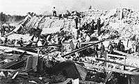black-and-white image of men digging through rubble