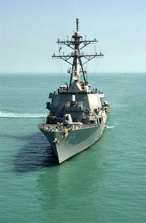 A grey warship in murky water