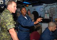 Air Traffic Controller 1st Class Erica Banks explains the SPN 43 Radar System to General Walter Natynczyk, Canadian chief of Defense Staff, in the amphibious air traffic control center aboard the amphibious assault ship USS Bonhomme Richard (LHD 6)