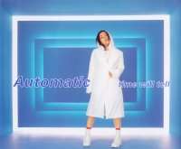 A body shot of a Japanese–American woman (Utada Hikaru) standing in front of a blue room, surrounded by led-lights. She is wearing white clothing and has her name and the songs title superimposed.