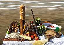 A table on which fruits and some wooden icons are situated