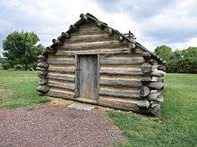 Photograph of a reproduction hut at Valley Forge National Historical Park, Pennsylvania.  The hut stands at the site of a recreated brigade encampment along North Outer Line Drive..