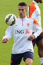Robin van Persie in a Netherlands national football team training top watching an airborne football