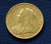 A gold coin, with the portrait of a veiled woman on it