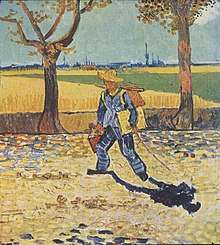 man wearing a straw hat, carrying a canvas and paintbox, walking to the left, down a tree lined, leaf strewn country road