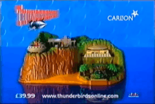 Scale, toy model of a tropical island, with stationary, futuristic air- and spacecraft and "Thunderbirds" and "Carlton" titles