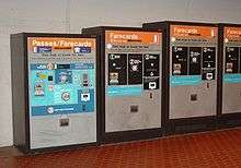 A row of fare-card machines, each with buttons, slots for money and farecards, and printed instructions.