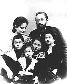 A middle-aged, bearded man, a younger woman and four children