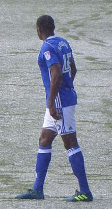 Black-skinned man in football kit on a snowy pitch