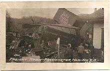 A derailed freight train with broken and mangled boxcars