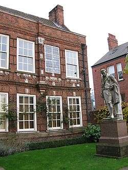 statue on a lawn of a two-storey Georgian house