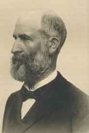 A thin, balding man with a black beard and mustache, facing left. He is wearing a white shirt, black bow tie, and black jacket