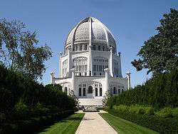 A white domed building with a large garden leading toward it