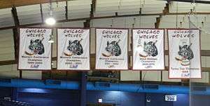 Five white banners hang from the ceiling. Each has the team name at the top with a stylized wolves head with a stick and puck behind it in the middle. At the bottom of each banner is wording explaining what each is for.