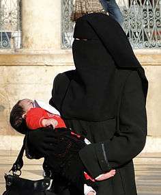 Woman wearing a niqab with baby