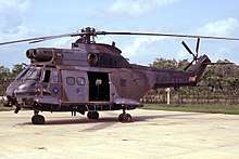 A helicopter sitting at rest on a concrete platform