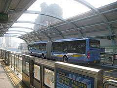 Blue articulated bus at a station