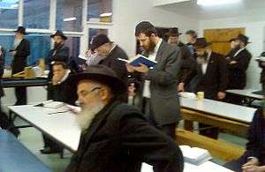 Orthodox-dressed men studying