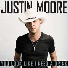 The cover has the artist in the center of a white background, wearing a black t-shirt and white cowboy hat with a black ring around it. Above the artist is his name boldly colored in black, and below him is the song title colored in teal against a black background.